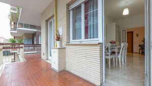 Un apartamento moderno con balcón, comedor y cocina a la vista.