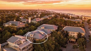 A coastal residential area with houses, a view of the ocean, and a highlighted building with a distinctive roof. - WaterColor Condo‑Retreat | 2.5BR/2BA - Bikes, Balcony, Walk to Beach Club (Santa Rosa Beach)
