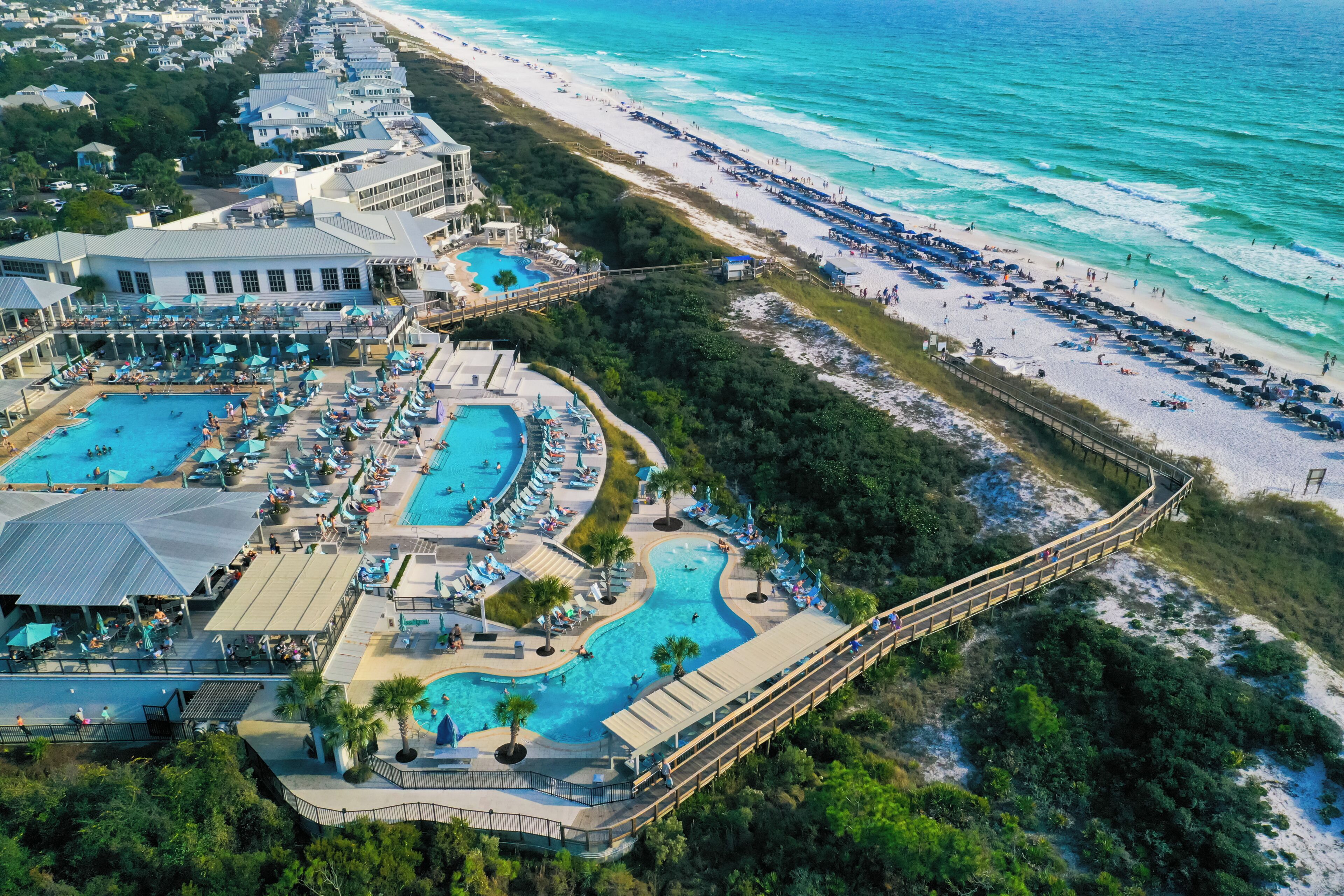Un resort con varias piscinas, playa y un paseo marítimo.