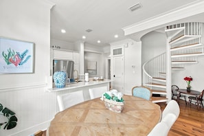 A modern kitchen with white cabinetry, a stainless steel refrigerator, and a built-in oven.