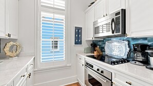 A modern kitchen with white cabinetry, a built-in oven, a microwave, and a coffee maker. - WaterColor Condo‑Retreat | 2.5BR/2BA - Bikes, Balcony, Walk to Beach Club (Santa Rosa Beach)