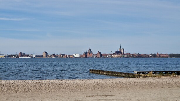 A waterfront cityscape with historic buildings and a clear sky.