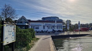 A waterfront restaurant with outdoor seating and a view of the water.