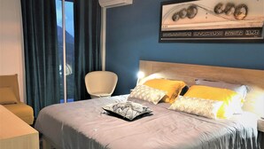 Une chambre d’hôtel avec un lit, une chaise et une fenêtre avec des rideaux.