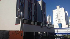 Een meerlaags gebouw met een platte gevel, grote ramen en een balkon.