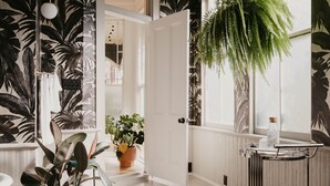 A room with a large window, a door leading to another room, and a potted plant on the windowsill. - Dreamers BNB (Wilmington)