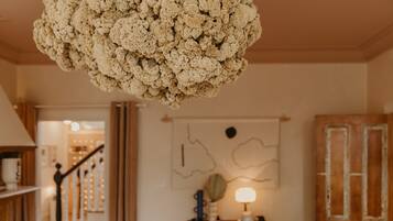 A room with a textured ceiling light fixture, a staircase, a chair, a wooden cabinet, and a door with a rustic finish.