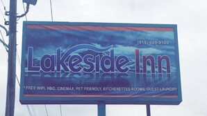 A billboard for Lakeside Inn advertising amenities like free WiFi, HBO, Cinemax, pet-friendly options, kitchenettes, and guest laundry. - Lakeside inn (Eufaula)