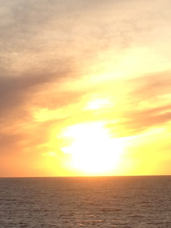 Un atardecer sobre el océano con cielo despejado.