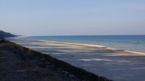 En strand med klar himmel och stilla hav.