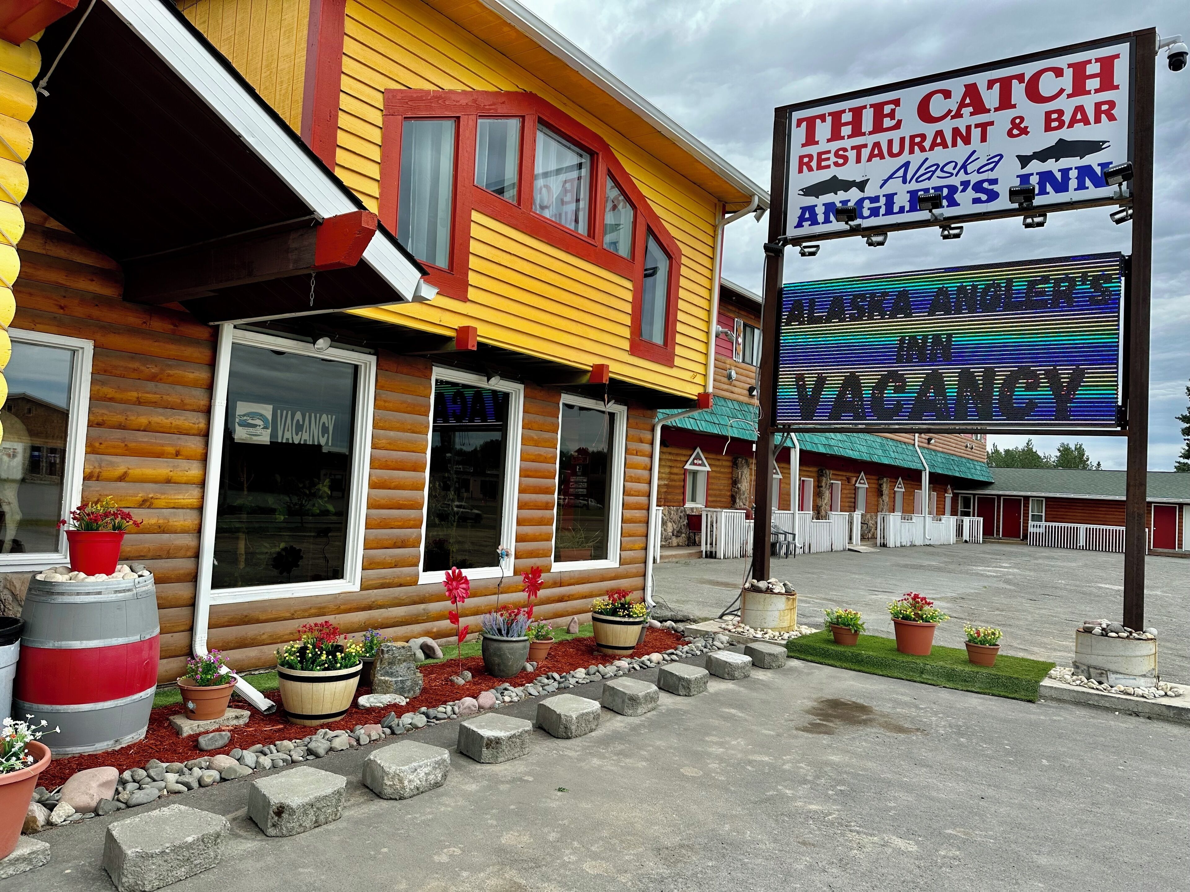 Un bâtiment de style cabane en rondins, avec une enseigne indiquant « The Catch Restaurant & Bar » et « Angler's Inn ».