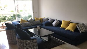 A living room with a blue sofa, patterned armchairs, and a coffee table.