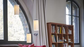 Una sala de estar moderna con un sofá rojo, una estantería y un amplio ventanal.