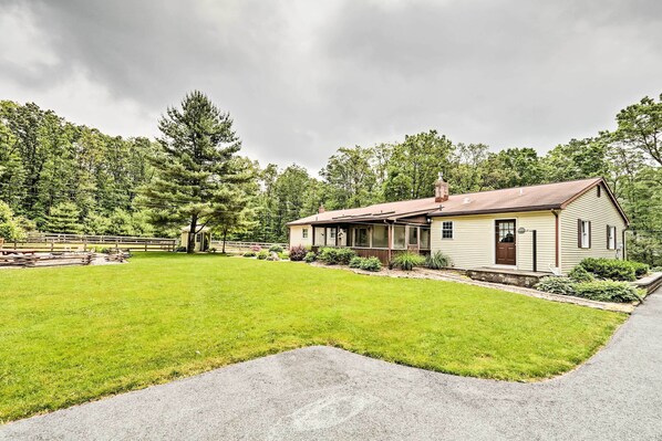 A single-story house with a front porch, a well-maintained lawn, and a wooden fence.