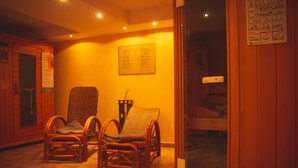A room with two wicker chairs, a small table, and a bed. - Hotel Alpenrose (Bad Woerishofen)