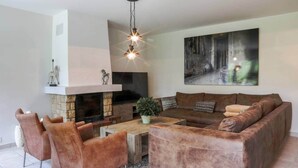 Una sala de estar con chimenea, un sofá, una mesa de centro y un televisor.