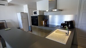 A modern kitchen with a large island, built-in appliances, and a stainless steel sink.