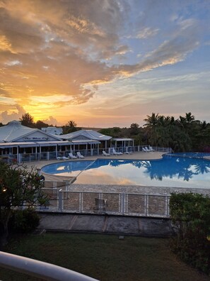 A resort with a swimming pool, lounge chairs, and a covered area with umbrellas. - Charming apartment, quiet at the luxury residence "La plantation Saint-Marthe" (saint-francois)