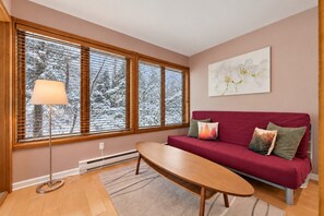 A living room with a sofa, a table, and a floor lamp.