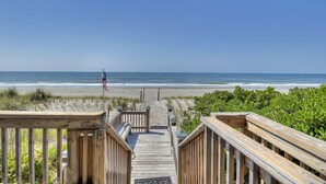 Una passerella di legno che conduce a una spiaggia, con vista libera sull'oceano.