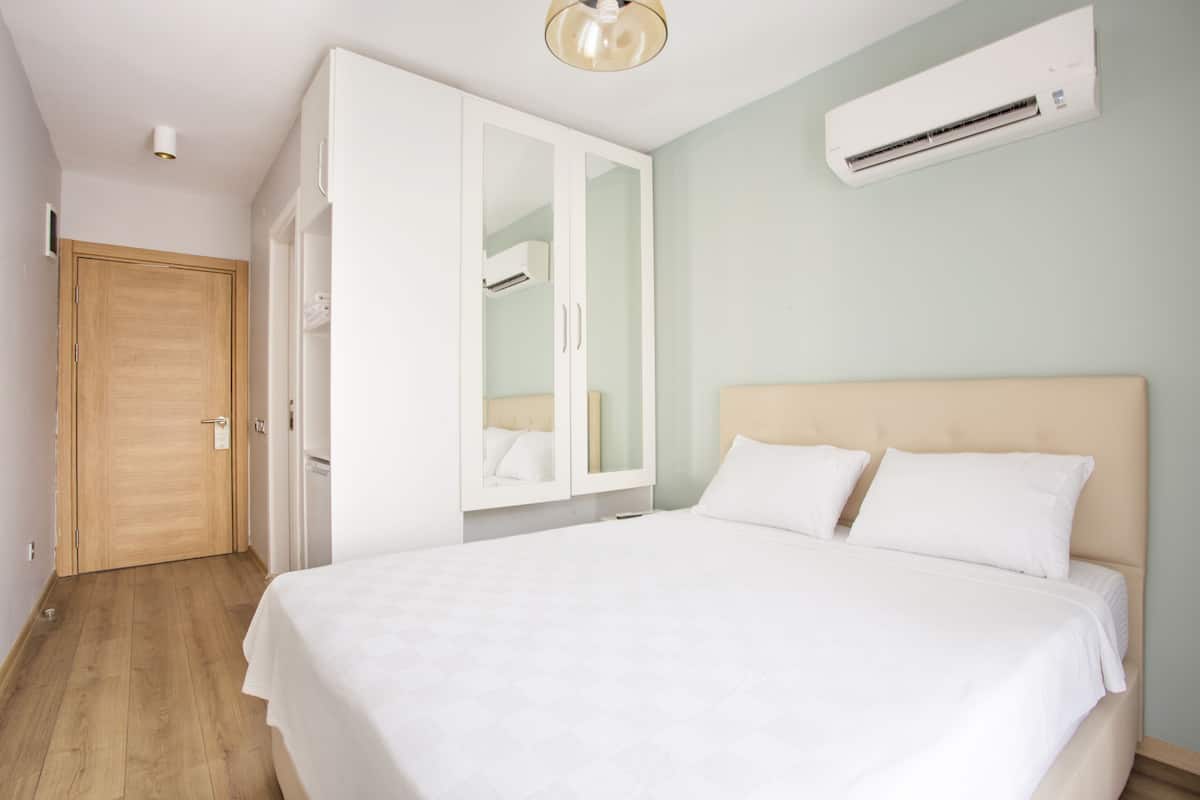 Un dormitorio con cama, armario y equipo de aire acondicionado.