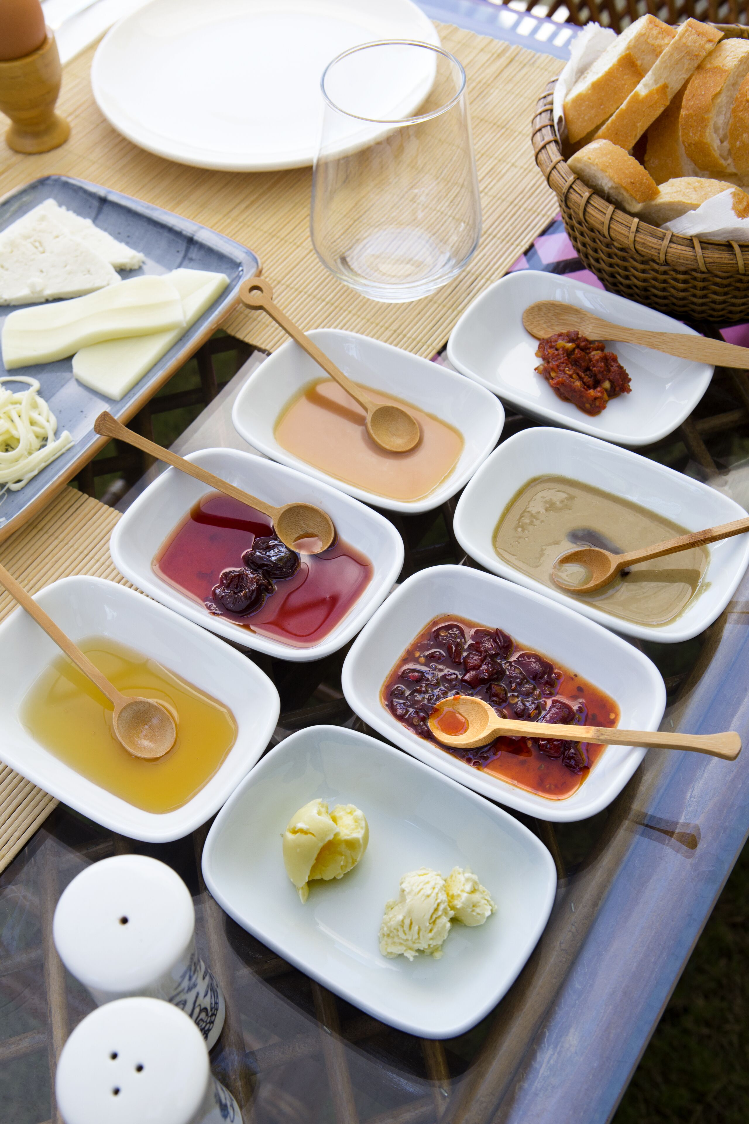 A table set with various dishes including bread, cheese, and condiments.