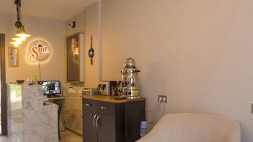 A modern kitchen with a marble countertop, a coffee machine, and a neon sign.