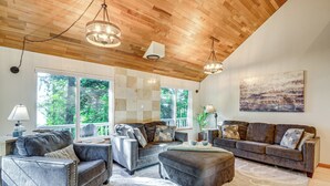 A spacious living room with a high wooden ceiling, large windows, and a view of the outdoors. - Oyster Haven: Private Oyster Beach w/Kayaks (Shelton)