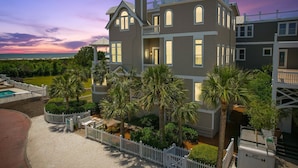 A multi-story house with a pool, surrounded by palm trees and a white fence. - Spectacular Ocean Views! Immaculate Family Oceanfront Home, Pool, Rooftop Deck! Emmeline Cottage (Saint Simons Island)