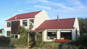 A two-story building with a red roof, large windows, and a sign reading "Posada de la Viuda". - Widow's Inn - Superior Double (Punta del Diablo, Rocha)