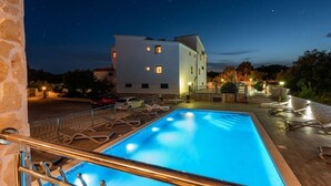 A swimming pool with a wooden deck and metal railings, surrounded by a stone wall. - Apartment in Vinišće with Balcony, Air condition, WIFI, Washing machine (4753-1) (Vinišce)