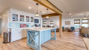 A spacious kitchen with a central island, wooden beams, and a tiled backsplash. - Life is Better at the Lake. Come relax at FishCamp@PK (Graford)