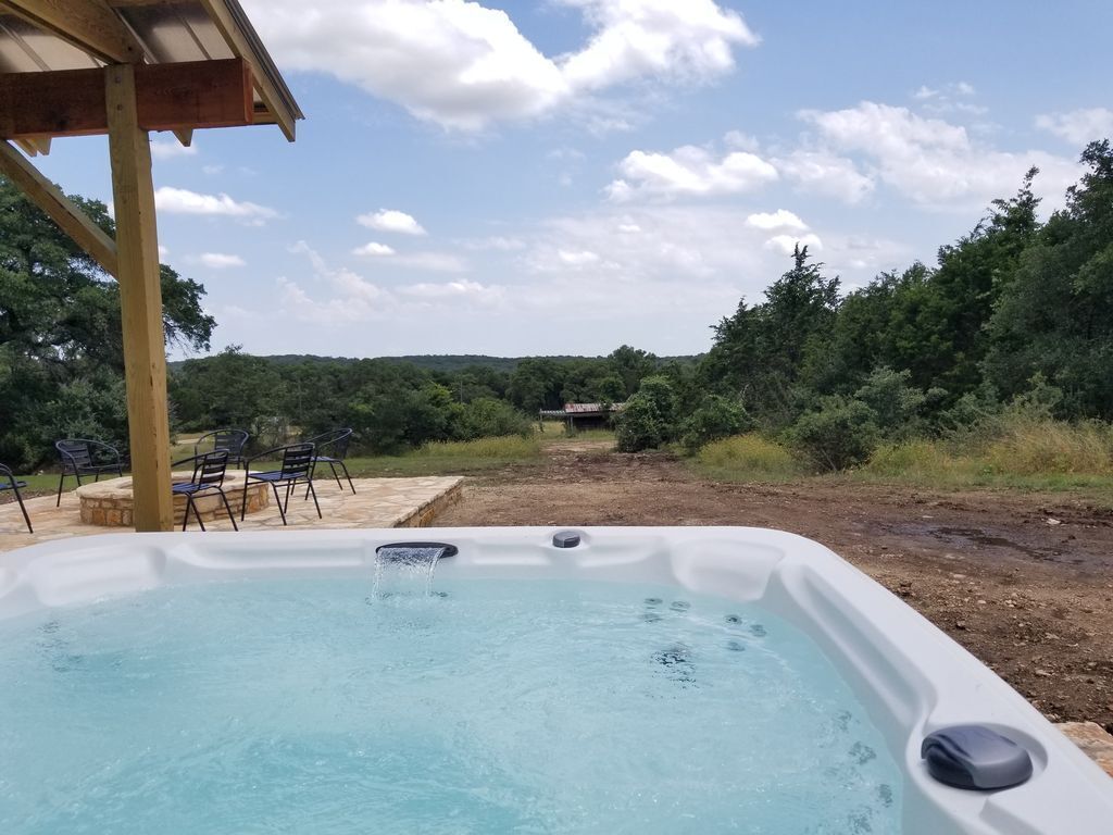 Ein Whirlpool mit einer Holz-Pergola und Stühlen im Garten.
