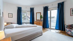 A bedroom with a bed, dresser, and a window with curtains. - Living Eden - TOP 3, city center & balcony (Zell am See)
