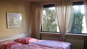 A bedroom with a bed, a radiator, and a window with curtains. - Many excursion destinations, e.g. Museumsdorf, wildlife park, Altes Land, opera, theater and musical. (Hamburg)