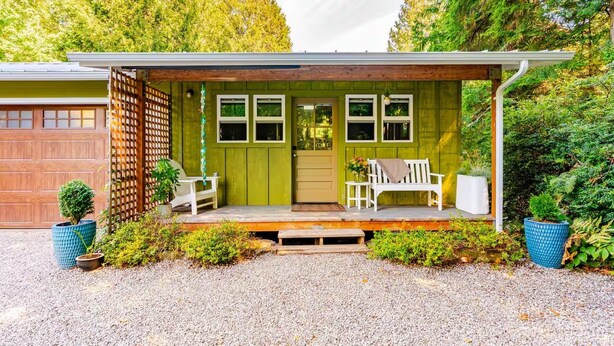 A house with a covered porch, a garage, and a front door. - Wooded Bainbridge Island Studio (Bainbridge Island)