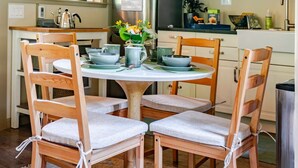A wooden ceiling, a dining table with chairs, and a kitchen area with cabinets and appliances. - Wooded Bainbridge Island Studio (Bainbridge Island)