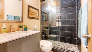 A bathroom with a shower, toilet, and vanity. - Wooded Bainbridge Island Studio (Bainbridge Island)