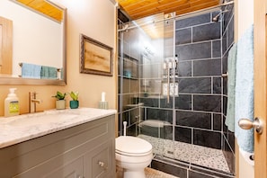 Un bagno con doccia, WC e mobile lavabo.
