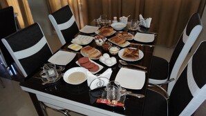 Una mesa lista para comer, con platos, tazones y diferentes alimentos.