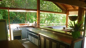 Cocina con estufa a gas, pileta y alacenas de madera.