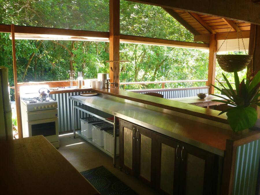 Cocina con estufa a gas, pileta y alacenas de madera.