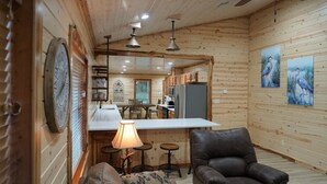 Interior acolhedor de cabana com área de jantar, cozinha e espaço para sentar.