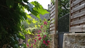A narrow alley with a stone wall on one side and a wooden fence on the other.