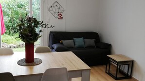 A modern living space with a dining area, a sofa, and a small table.