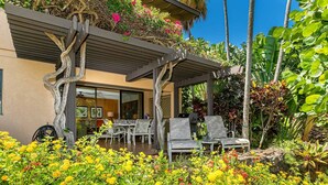 Une terrasse extérieure moderne, agrémentée d’une pergola, d’un espace salon et d’un jardin luxuriant.