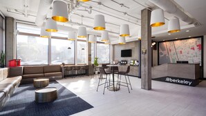 Un interior moderno con mostrador de recepción, zona de estar y ventanas amplias.