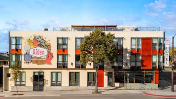 A modern hotel with a large mural advertising Aiden by Best Western.