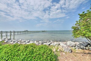 Escape to a serene coastal haven with a tranquil pier and lush green surroundings.