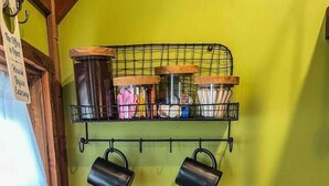 A kitchen with a wooden countertop, a stainless steel sink, and a hanging rack with mugs and utensils. - Escape. Just You. Peace, Animals & Nature (Longview)